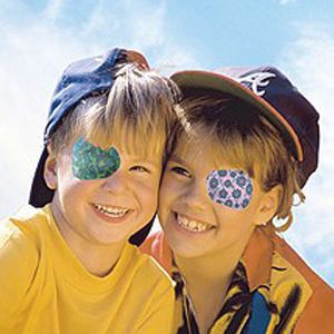 Two children with eye patches on their faces.