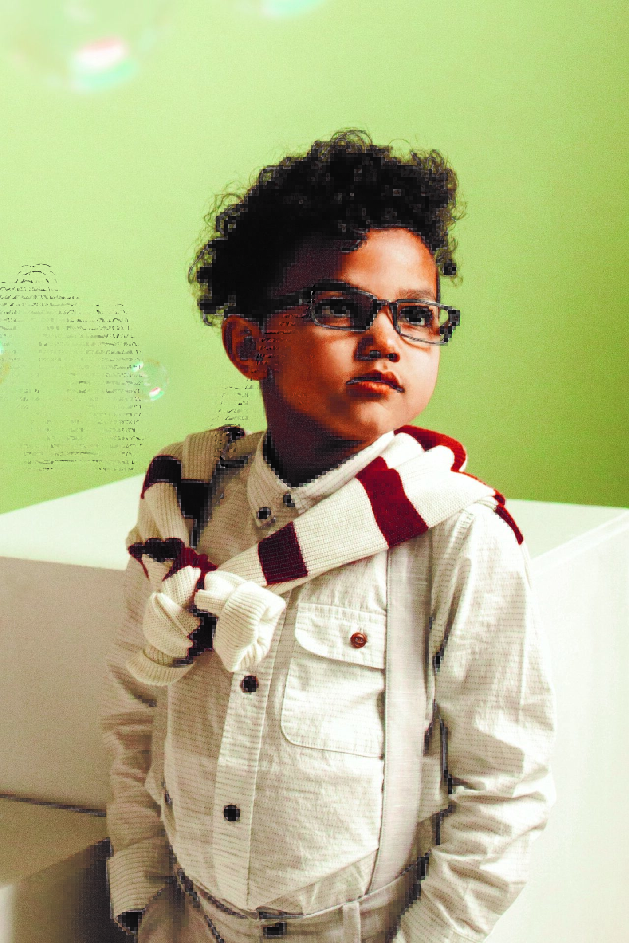 A young boy wearing glasses and a scarf.