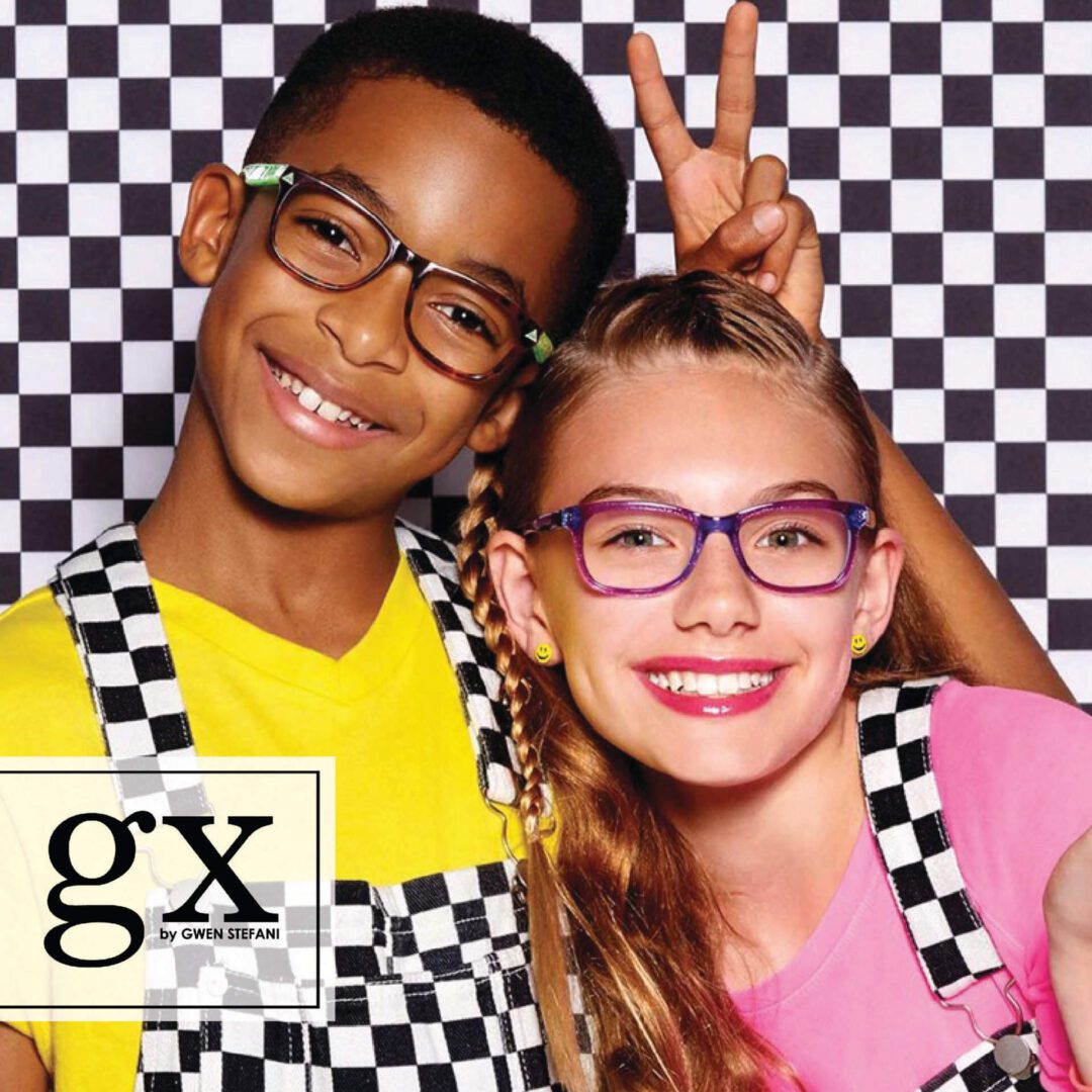 Two kids posing for a picture in front of a checkered background.